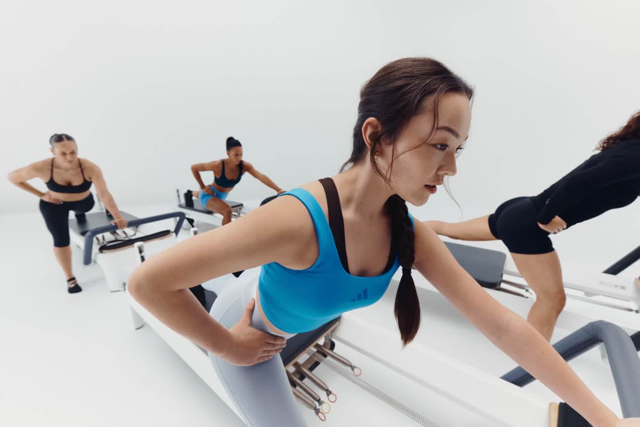 Gruppe beim Training auf Reformern in einem hellen Pilates-Studio